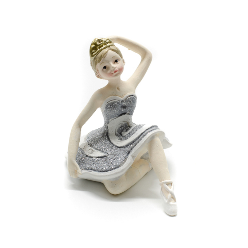 Ezüst csillogó tütüben kecsesen ülő és fejét érintő balerina