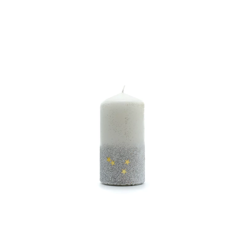 Közepes méretű tömbgyertya, az alsó harmadát arany csillámpor borítja kis arany csillagokkal